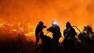 Firefighters battle with a large wildfire burning in Kofinas on the eastern Aegean island of Chios, 22 June, 2025