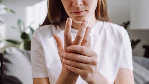 A woman with arthritis holds her wrist.