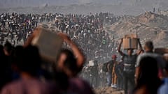 Palästinenser tragen Lebensmittel und humanitäre Hilfsgüter, die aus einem Konvoi des Welternährungsprogramms ausgeladen wurden, der auf dem Weg nach Gaza-Stadt war, im nördlichen Gazastreifen, Montag, 16. Juni 2025.