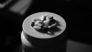 Las pastillas están encima de un frasco.