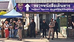 Taylandlı bir polis memuru, Tayland'ın Sa Kaeo Eyaleti'nde Tayland ve Kamboçya arasındaki sınır kontrol noktası yakınlarında insanlarla konuşuyor, 24 Haziran, 2025