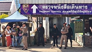 Un agente de policía tailandés habla con la gente cerca de un puesto de control fronterizo entre Tailandia y Camboya, en la provincia tailandesa de Sa Kaeo, 24 de junio de 2025.