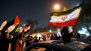 Manifestantes concentram-se em frente à Embaixada do Irão com bandeiras iranianas para celebrar o cessar-fogo entre o Irão e Israel, em Bagdade, Iraque. 24 de junho de 2025.