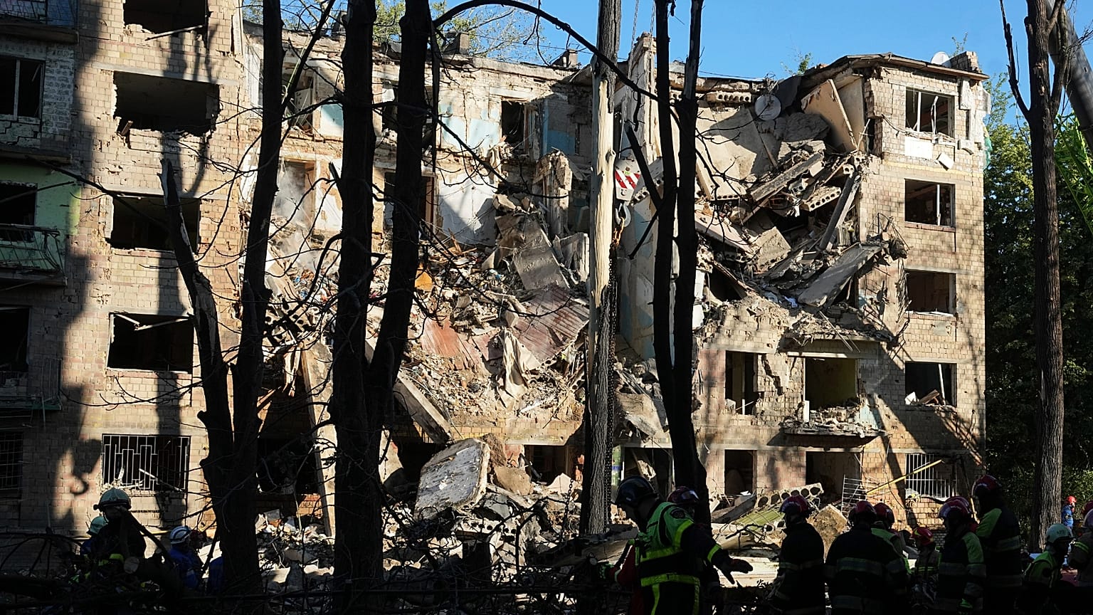 Os bombeiros trabalham num edifício de apartamentos destruído após um ataque russo em Kiev, Ucrânia, na madrugada de segunda-feira, 23 de junho de 2025.
