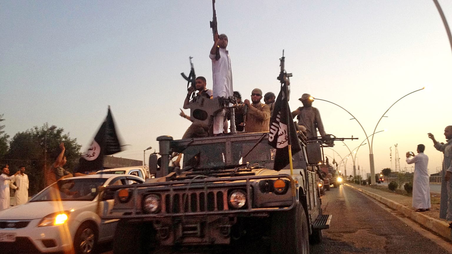 İslam Devleti militanları kuzeydeki Musul kentinde Irak güvenlik güçlerinin el koyduğu bir zırhlı araçla geçit töreni yapıyor, 23 Haziran 2014