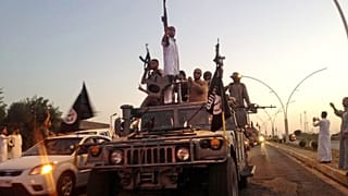 Islamic State militants parade in a commandeered Iraqi security forces armoured vehicle in the northern city of Mosul, 23 June, 2014
