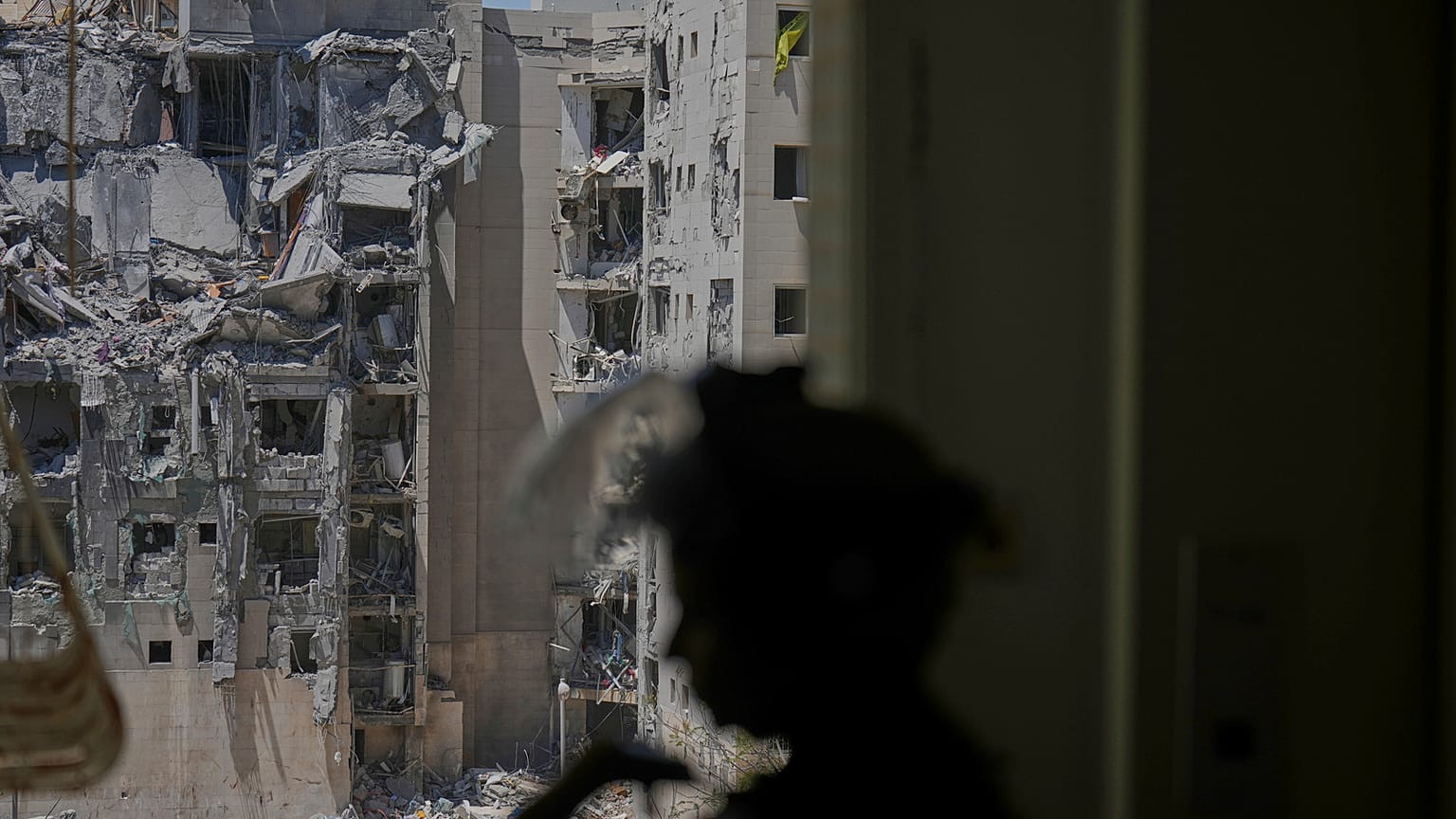 Um agente da polícia inspeciona um apartamento danificado, um dia depois de um ataque direto de mísseis do Irão ter atingido um edifício em Beersheba.