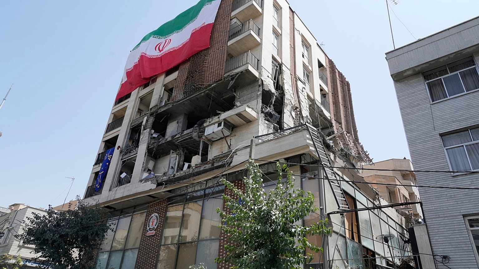 علم إيراني معلق على مبنى تعرض لضربة إسرائيلية الأسبوع الماضي ، في طهران ، إيران ، الأربعاء ، 25 يونيو ، 2025.