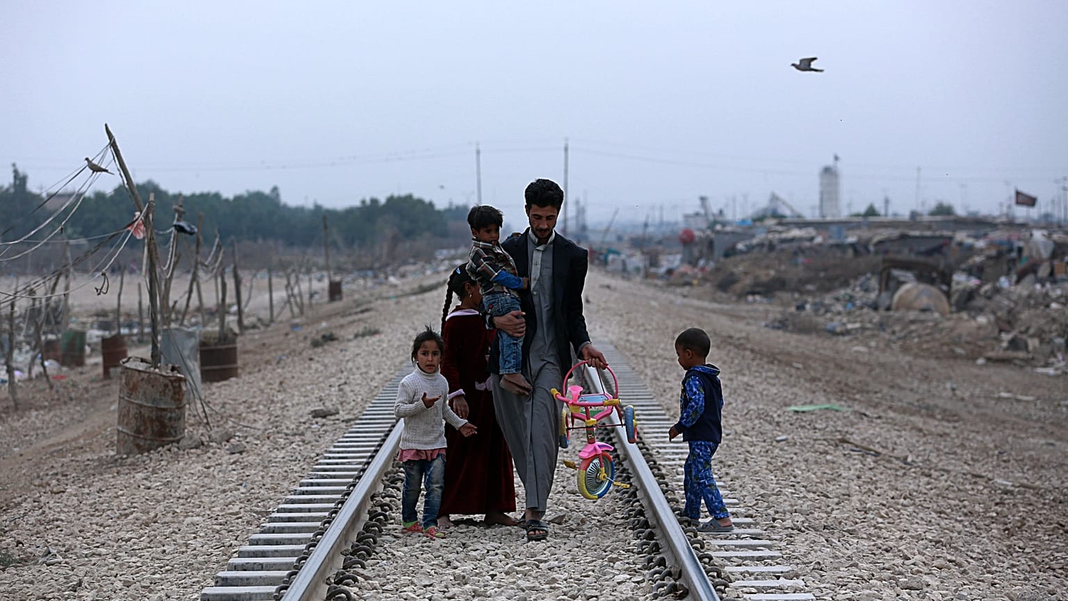 Evsiz bir Iraklı aile tren rayları boyunca Bağdat'ın dışındaki kulübelerine doğru yürüyor, 12 Şubat 2018