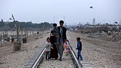 Evsiz bir Iraklı aile tren rayları boyunca Bağdat'ın dışındaki kulübelerine doğru yürüyor, 12 Şubat 2018