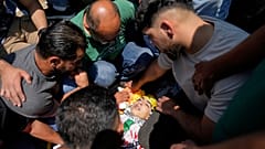 يلقي المشيعون النظرة الأخيرة على جثمان الفلسطيني عمار حمايل (13 عاما)، الذي قالت وزارة الصحة الفلسطينية إنه قُتل برصاص الجيش الإسرائيلي يوم الاثنين، خلال جنازته 