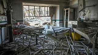  عناصر إنقاذ يفتشون بين أنقاض جزء متضرر من سجن إيفين بعد ضربة إسرائيلية، طهران، 24 حزيران/يونيو 2025.