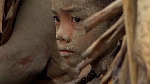 Un jeune garçon couvert de boue assiste à un rituel imprégné de foi et d'histoire, Northern Luzon, PHILIPINES, 24.06.2025