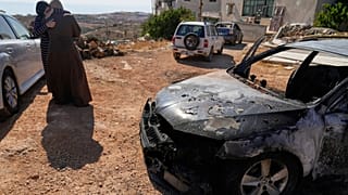 Γυναίκες παρηγορούν η μία την άλλη δίπλα σε όχημα που κάηκε κατά τη διάρκεια της νύχτας από ισραηλινούς εποίκους σε μια επίθεση που άφησε πίσω της τρεις Παλαιστίνιους νεκρούς και έκαψε πολλά οχήματα και κατέστρεψε σπίτι