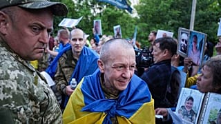 Soldados ucranianos caminan por un corredor humano después de regresar de su cautiverio tras un intercambio de prisioneros de guerra entre Rusia y Ucrania, Chernyhiv, Ucrania, jueves 26 de junio de 2025.