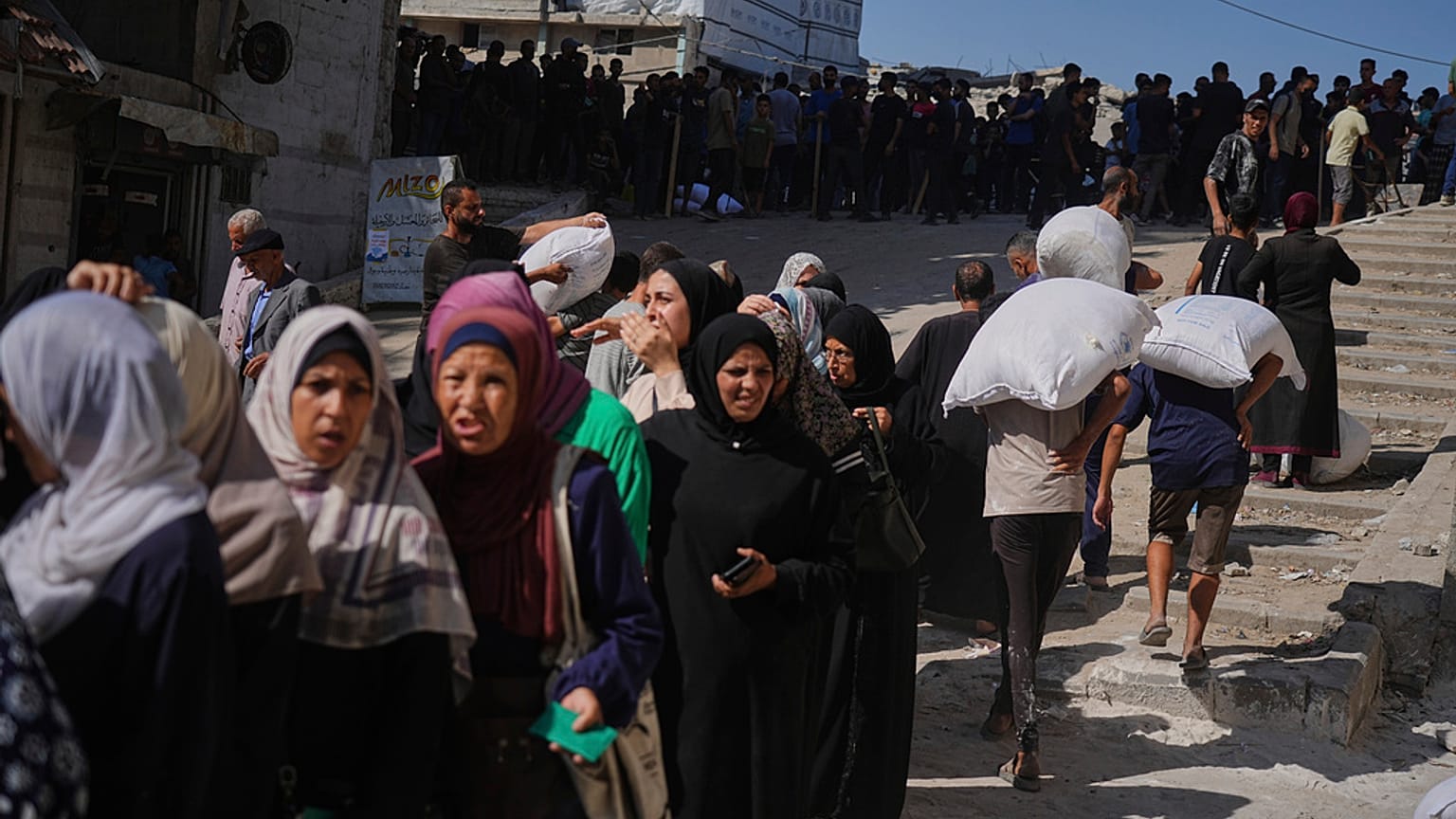 فلسطينيون يصطفون لاستلام أكياس الطحين التي يوزعها برنامج الأغذية العالمي في مدينة غزة، شمال قطاع غزة، يوم الخميس، 26 يونيو 2025.