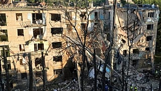 Os bombeiros trabalham num edifício de apartamentos destruído após um ataque russo em Kiev, Ucrânia, na madrugada de segunda-feira, 23 de junho de 2025.