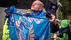 Ein freigelassener ukrainischer Soldat hält nach einem Gefangenenaustausch mit Russland die Flagge seiner Einheit hoch