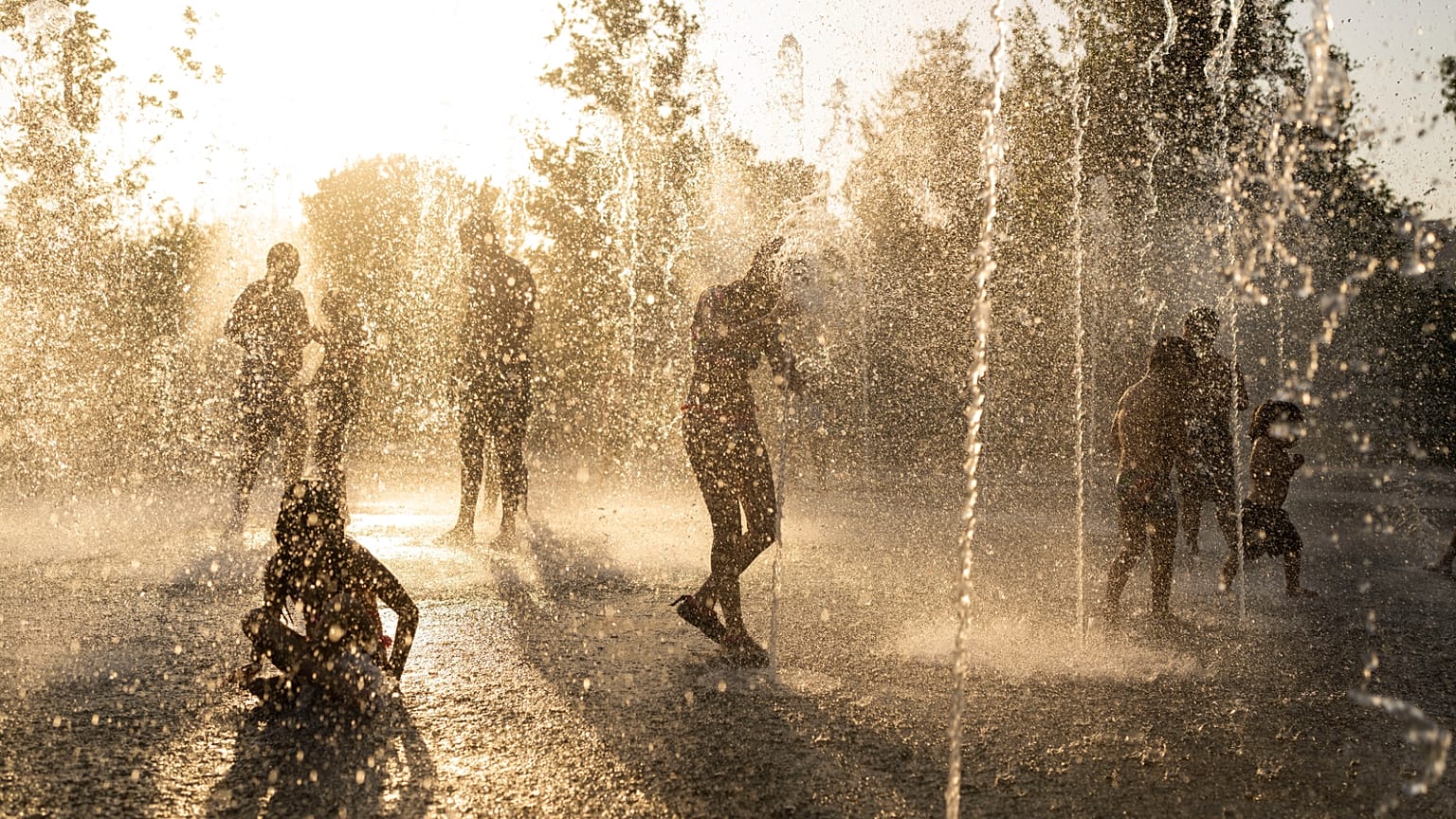Children play with water at a fountain during a heatwave in Athens, 21 July, 2023