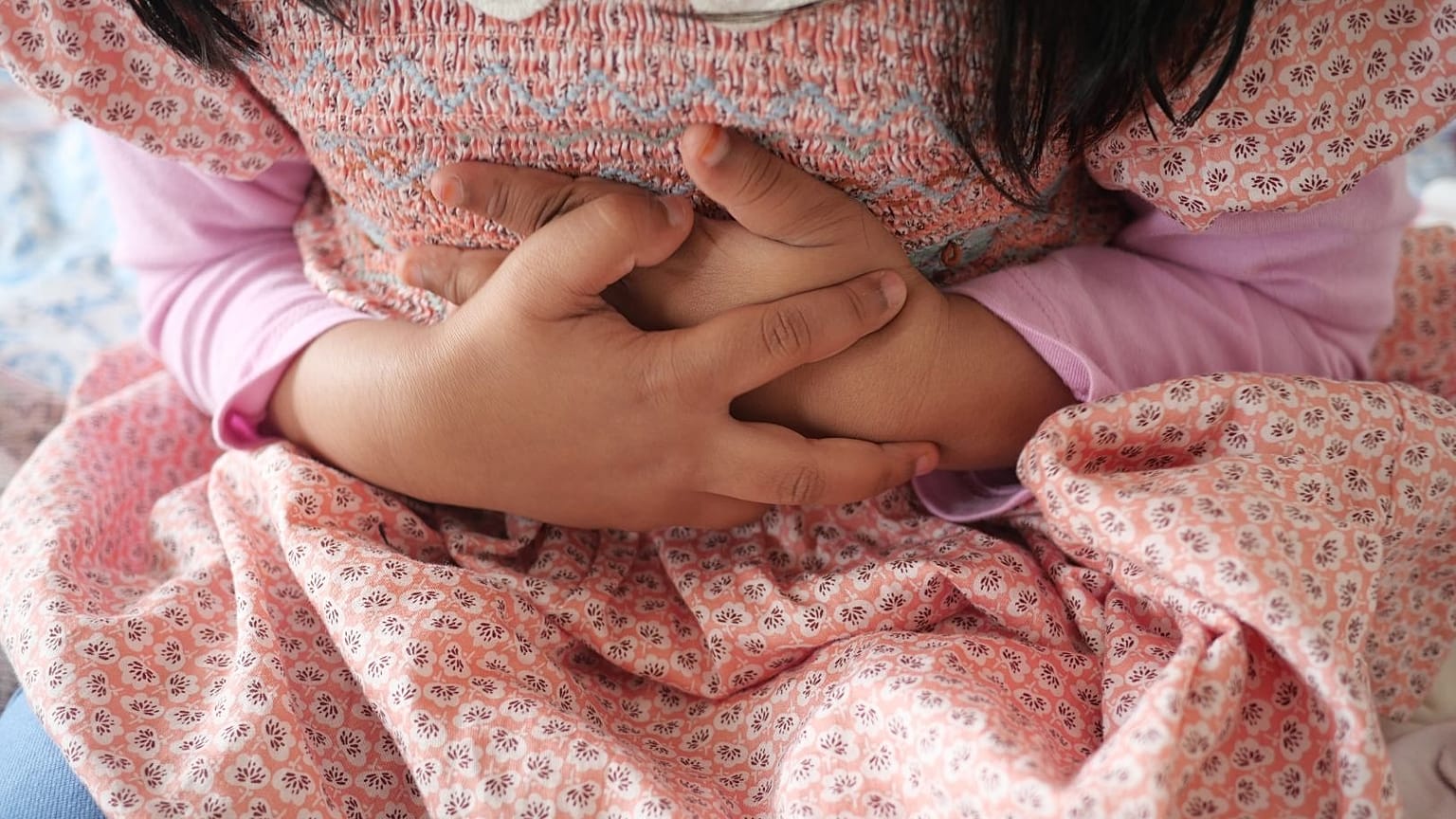 Une jeune fille ressent des douleurs à l'estomac.