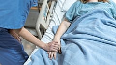 Ein Arzt hält die Hand eines Patienten.
