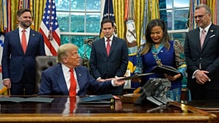 Президент Трамп вручает подписанный документ министру иностранных дел Конго во время встречи в Белом доме, на которой присутствовал глава МИД Руанды, 27 июня 2025 г.. 
