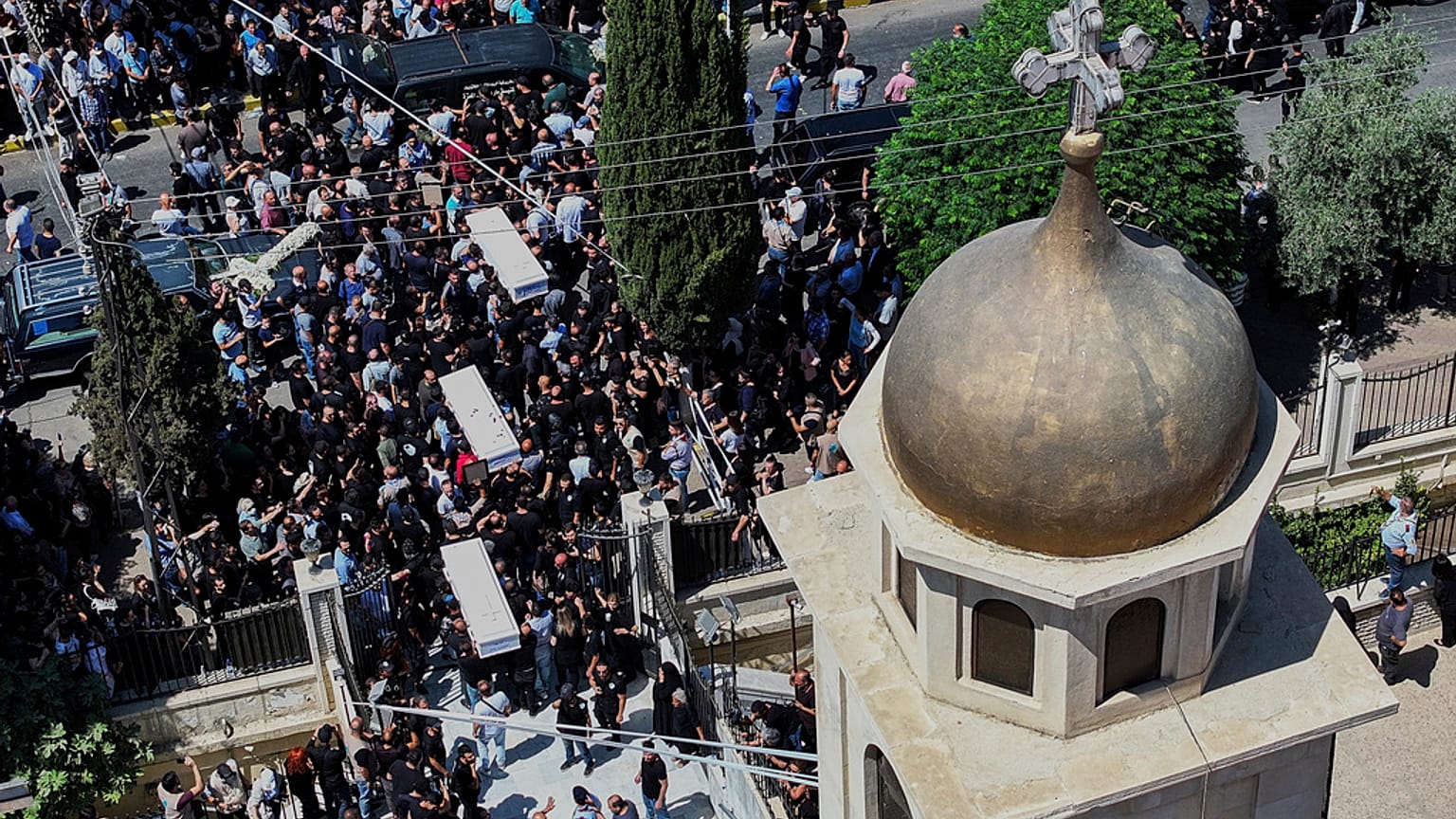 مشيعون يحملون توابيت الضحايا الذين قتلوا في التفجير الانتحاري الذي وقع يوم الأحد في كنيسة مار الياس خلال موكب جنازة في كنيسة الصليب في حي القصاص بدمشق ، سوريا ، الثلاثاء 24 يو