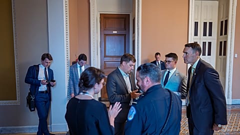 Congressional staff wait outside a Republican meeting