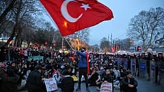  طلاب جامعيون يجلسون بجانب ضباط شرطة مكافحة الشغب خلال احتجاج بعد اعتقال رئيس بلدية إسطنبول أكرم إمام أوغلو وإرساله إلى السجن، في إسطنبول، تركيا، الاثنين، 24 مارس/آذار 2025