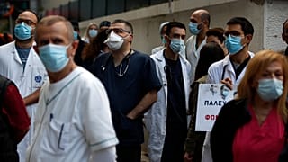 Health workers wearing face masks to protect against the spread of the coronavirus, take part in a protest at Evangelismos hospital in Athens, Thursday, Nov. 12, 2020.