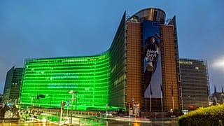The European Commission building lit up in green for the European Green Pact