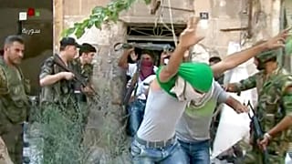 فيديو بثه التلفزيون السوري الرسمي يُظهر شبانًا ملثمين وهم يسلمون أنفسهم لقوات الحكومة في مدينة حلب، شمال سوريا.
