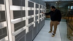Ράφια διακομιστών υπολογιστών που εκτελούν προγράμματα τεχνητής νοημοσύνης χρησιμοποιώντας μικροτσίπ.