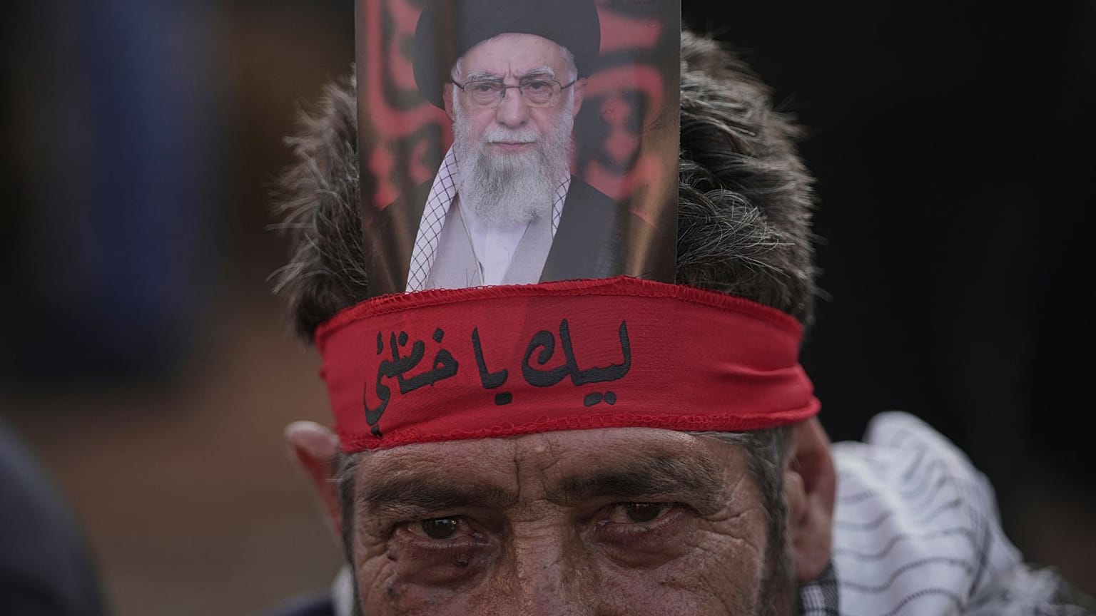 Um apoiante do Hezbollah posa com uma foto de Ali Khamenei em frente à Embaixada do Irão em Beirute a 25 de junho 