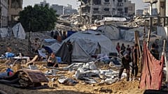 Palestinesi ispezionano le tende danneggiate dopo che un attacco israeliano ha colpito un campo di sfollati a Gaza City, sabato 28 giugno 2025.