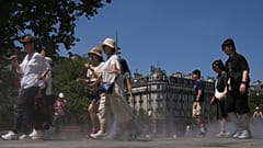 يتجول السياح عبر بخار الماء العذب الذي يتم رشه على الأرض أثناء اختبار الرذاذ، خلال موجة الحر يوم الاثنين، 30 يونيو 2025 في باريس