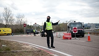 Una señal de tráfico junto a un agente de policía en Igualada, España.