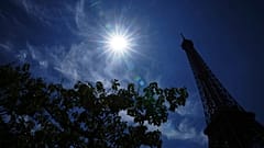 Ο ήλιος λάμπει πάνω από τον Πύργο του Άιφελ κατά τη διάρκεια καύσωνα, Δευτέρα 30 Ιουνίου 2025 στο Παρίσι.