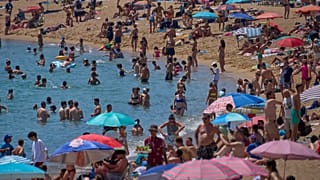 Κολυμβητές δροσίζονται στο νερό σε μια παραλία σε μια ζεστή μέρα στη Βαρκελώνη, Ισπανία, Σάββατο 28 Ιουνίου 2025.