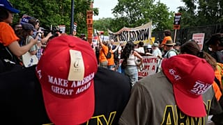 Cappellini di Trump in vendita negli Usa sullo sfondo di una protesta contro la parata svoltasi per celebrare l'esercito e il compleanno del Presidente (14 giugno 2025)