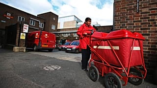 Ένας υπάλληλος της Royal Mail βγαίνει από μια αποθήκη ταχυδρομείου στο Λονδίνο, Πέμπτη 10 Οκτωβρίου 2013. 