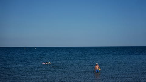 Plażowicze cieszą się morzem podczas fali upałów w poniedziałek 30 czerwca w Saintes-Maries-de-la-Mer w południowej Francji.