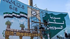 متطوعون يرسمون "جرافيتي النصر" في الساحة الرئيسية بإدلب، سوريا