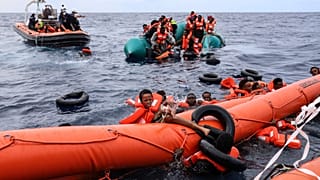 Migránsok egy gumicsónak fedélzetén a Líbia melletti vizeken, mielőtt a Sea Watch-3 csapata megmenti őket 2021. október 18-án