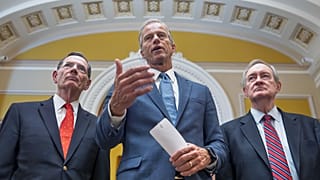 Senate Majority Leader John Thune, centre, speaks to reporters just after passage of the budget package in Washington, 1 July, 2025