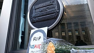 FILE - Flowers and a sign are placed outside the headquarters of the U.S. Agency for International Development, or USAID, Feb. 7, 2025, in Washington