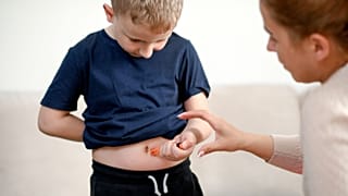 Uma criança injecta insulina.