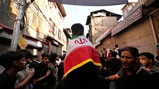 Un niño se cubre los hombros con una bandera iraní