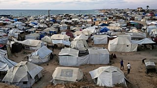 Palestinians displaced by the Israeli air and ground offensive on Gaza Strip, stand in an area at a makeshift tent camp in Khan Younis, Gaza Strip, Wednesday, July 2, 2025.