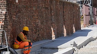 Un operaio fa una pausa all'ombra in un cantiere stradale, Milano, Italia, 2 luglio 2025
